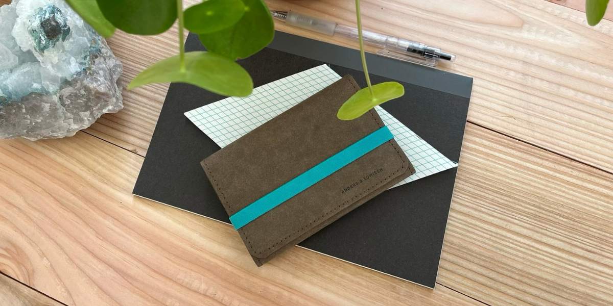 Slim Wallet Fahrzeugschein – kompaktes Portemonnaie für Männer & Frauen, auf einem Schreibtisch mit Stift, Pflanze und Block zur Größenveranschaulichung.